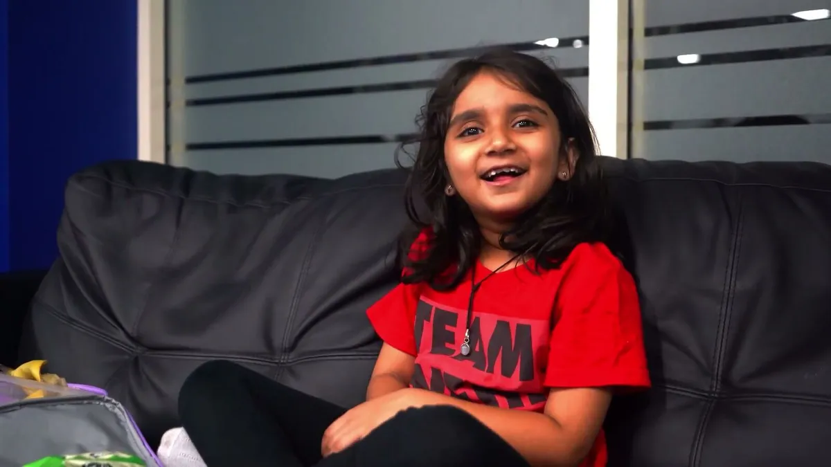 Sol’s daughter Inaya, smiling on the couch