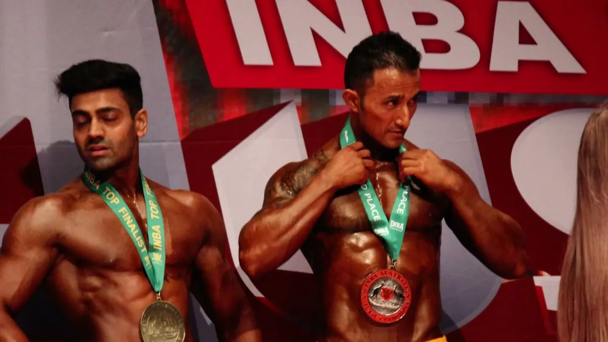 Sol wearing a competition medal in front of an INBA banner